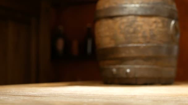 A mão humana coloca uma caneca de cerveja de madeira velha na mesa no fundo de um pequeno barril para bebidas. Pratos no pub . — Vídeo de Stock