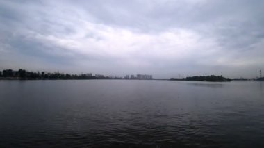 Şehrin kıyıya yelken bir gemi nehirden Time-Lapse video. Kasvetli hava akşam. Su taşıma yelken tarafından.