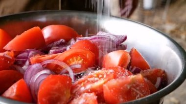 Dilimlenmiş domates ve mavi soğan salata ile büyük deniz tuzu serpilir. Sağlıklı gıda vitaminler sebze.