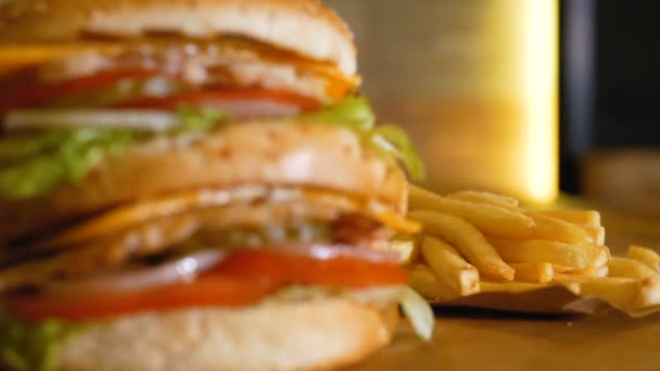 Gebakken aardappelen en Hamburger close-up. Heerlijke ongezond voedsel. Overdracht van focus tussen objecten. Professioneel gekookte fastfood. — Stockvideo
