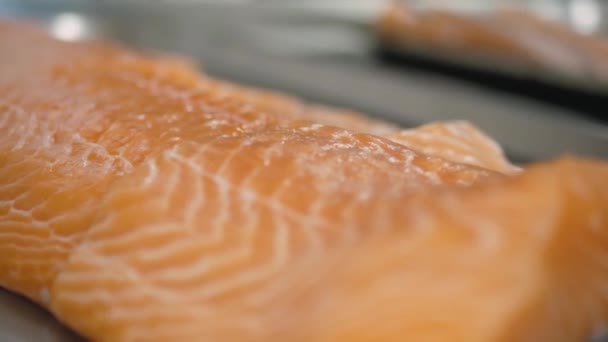 Human hands take a piece of sliced salmon fillet close-up. — Stock Video