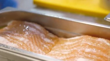 Bol tuzlu somon fileto dilimleri yakın çekim pişirmeden önce korunması için zeytinyağı dökün.