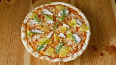 Bir daire içinde dönen ananas ve tavuk ile Pizza. Fast food. Yukarıdan görüntüle