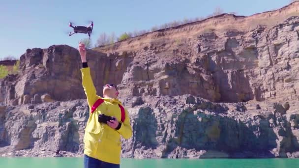 Drone pilot catching the drone in fly. Slow motion. Young man controls a drone using a remote control with joysticks. — Stock Video