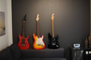 Kanepede farklı renklerde üç elektrik gitar