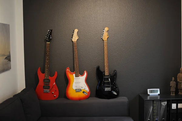 Kanepede farklı renklerde üç elektrik gitar