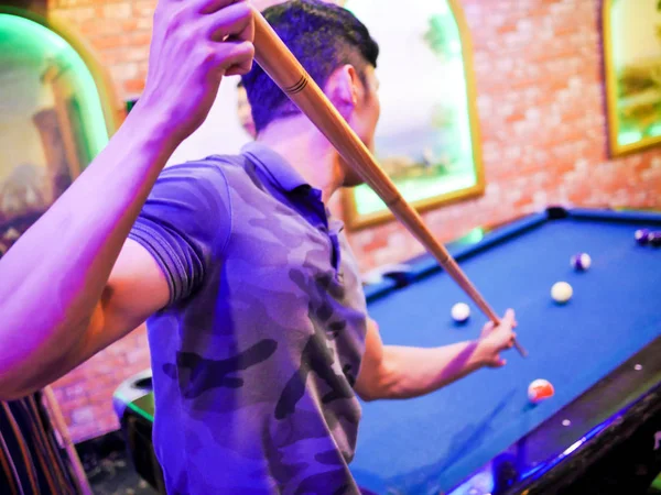 Junger Mann spielt Billard im bunten Club - mit weißer Kugel zum Schießen — Stockfoto