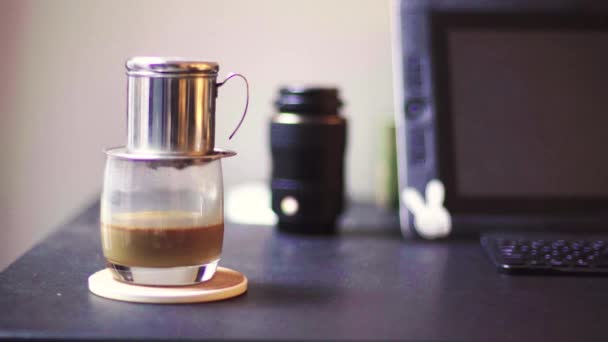 Sabahleyin masada Vietnam sütlü kahve. Kahve bardağı çalışma masasının üzerine düşer.. — Stok video