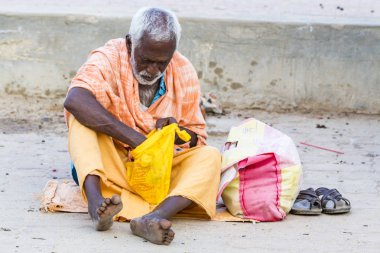 Kimliği belirsiz Sadhus hacılar adanmışlar, portresi giyinmiş turuncu giysileri, yolda, Gıda için bekleyen sokakta oturan.