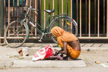 Kimliği belirsiz Sadhus hacılar adanmışlar, portresi giyinmiş turuncu giysileri, yolda, Gıda için bekleyen sokakta oturan.