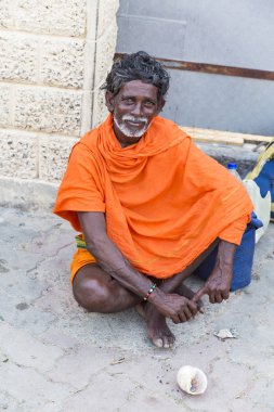 Kimliği belirsiz Sadhus hacılar adanmışlar, portresi giyinmiş turuncu giysileri, yolda, Gıda için bekleyen sokakta oturan.