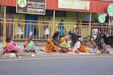 Grup Kimliği belirsiz Sadhus hacılar adanmışlar, Gıda için bekleyen road, sokakta oturan Turuncu elbise giymiş. Herhangi bir ev, açık yaşam.