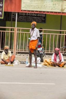 Grup Kimliği belirsiz Sadhus hacılar adanmışlar, Gıda için bekleyen road, sokakta oturan Turuncu elbise giymiş. Herhangi bir ev, açık yaşam.
