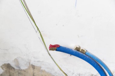 Duvardaki, Polipropilen Pex evde sıhhi tesisat su boruları yapılmıştır. Kanalizasyon boruları bir daire iç banyoda yükleme yenileme çalışmaları sırasında. Mavi plastik drenaj borusu için kullanılan su
