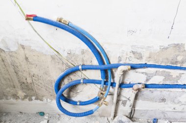 Duvardaki, Polipropilen Pex evde sıhhi tesisat su boruları yapılmıştır. Kanalizasyon boruları bir daire iç banyoda yükleme yenileme çalışmaları sırasında. Mavi plastik drenaj borusu için kullanılan su