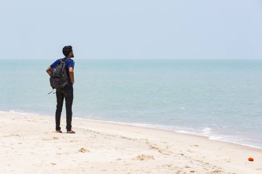 Kimliği belirsiz genç adam güzel güneşli sabah Danushkodi plajda yürüyor. Güzel, özgürlük.