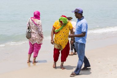 Belgesel yayın. Yaklaşık, Danushkodi, Pamban Adası, Tamil Nadu, Hindistan - 2018 Mart. Belirsiz bir aile kadın erkek çocuk güzel güneşli sabah Danushkodi kumsalda bir yürüyüşe. Hacılar Rameswaram üzerinden. Hindistan