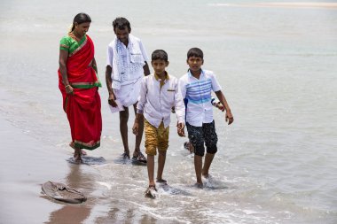 Belgesel yayın. Yaklaşık, Danushkodi, Pamban Adası, Tamil Nadu, Hindistan - 2018 Mart. Belirsiz bir aile kadın erkek çocuk güzel güneşli sabah Danushkodi kumsalda bir yürüyüşe. Hacılar Rameswaram üzerinden. Hindistan