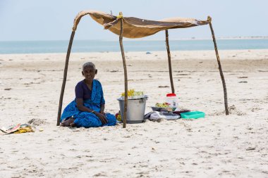 Belgesel yayın. Yaklaşık, Danushkodi, Pamban Adası, Tamil Nadu, Hindistan - 2018 Mart. Kimliği belirsiz bir kadın meyve fıstık Danushkodi beach bir çadırın altında satmak. Hindistan