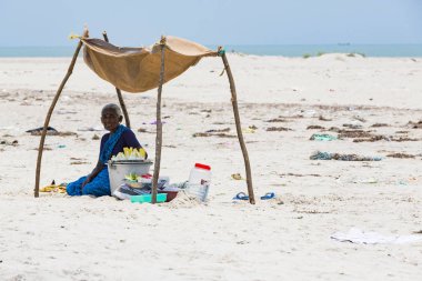 Belgesel yayın. Yaklaşık, Danushkodi, Pamban Adası, Tamil Nadu, Hindistan - 2018 Mart. Kimliği belirsiz bir kadın meyve fıstık Danushkodi beach bir çadırın altında satmak. Hindistan