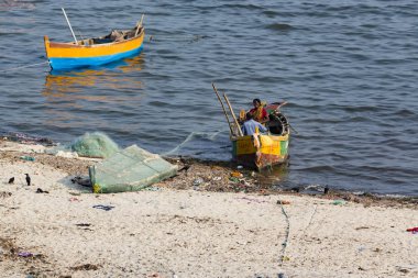 Belgesel yayın. Yaklaşık, Rameswaram, Rameshwaram, Pamban Adası, Tamil Nadu, Hindistan - 2018 Mart. Kimliği belirsiz zavallı yerel geleneksel balıkçı çok küçük renkli ahşap tekne ile sahilde balık. Asya