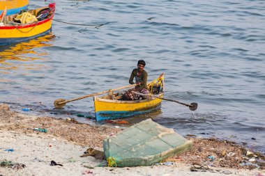 Belgesel yayın. Yaklaşık, Rameswaram, Rameshwaram, Pamban Adası, Tamil Nadu, Hindistan - 2018 Mart. Kimliği belirsiz zavallı yerel geleneksel balıkçı çok küçük renkli ahşap tekne ile sahilde balık. Asya