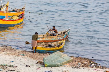 Belgesel yayın. Yaklaşık, Rameswaram, Rameshwaram, Pamban Adası, Tamil Nadu, Hindistan - 2018 Mart. Kimliği belirsiz zavallı yerel geleneksel balıkçı çok küçük renkli ahşap tekne ile sahilde balık. Asya