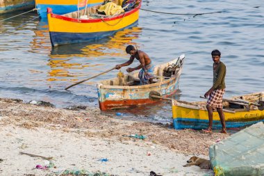 Belgesel yayın. Yaklaşık, Rameswaram, Rameshwaram, Pamban Adası, Tamil Nadu, Hindistan - 2018 Mart. Kimliği belirsiz zavallı yerel geleneksel balıkçı çok küçük renkli ahşap tekne ile sahilde balık. Asya