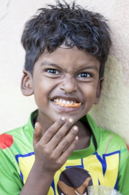 Pondichery, Puducherry, Tamil Nadu, Hindistan - Eylül yaklaşık, 2017. Kimliği belirsiz bir yoksul Hintli çocuk sokakta onun aperatif yemek portresi. Vlose-up