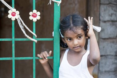 Yaklaşık, Pondichery, Puducherry, Tamil Nadu, Hindistan - 2018 Mart. Closeup uzağa bakarak ve saçları ile oynarken tanımlanamayan utangaç çekingen genç çok Hintli kız çocuk portresi. Utangaç kavramı.