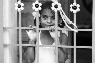 Yaklaşık, Pondichery, Puducherry, Tamil Nadu, Hindistan - 2018 Mart. Portre seyir uzakta ve kapı arkasında tanımlanamayan utangaç çekingen genç çok Hintli kız çocuk portresi. Özgürlük kavramı. Siyah ve beyaz