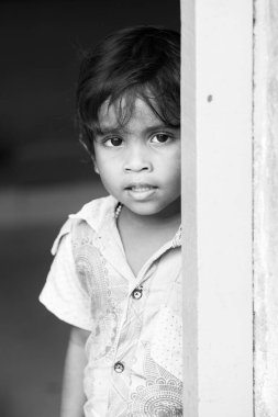 Pondichery, Puducherry, Tamil Nadu, Hindistan - Eylül yaklaşık, 2017. Kimliği belirsiz Hint zavallı çocuk çocuk portresi açık sokakta gülümsüyor. Siyah ve beyaz