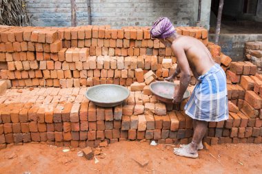 Pondichery, Puducherry, Tamil Nadu, Hindistan - Eylül yaklaşık, 2018. Kimliği belirsiz işçi inşaat alanında iş. İş kırmızı tuğla bir duvar bırakmaya başladı.