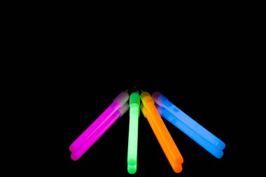 Renkli floresan ışık neon kızdırma ayna yansıması siyah arka plan üzerinde sopa. Mavi pembe turuncu yeşil büyük parlaklık sopa