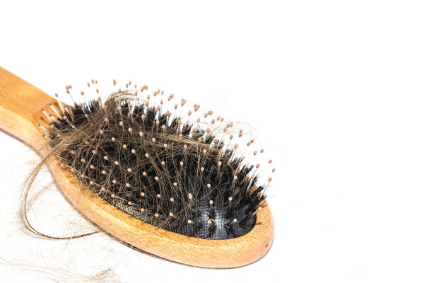 Hair loss on washbasin. Long brown hair with wood brush on white basin in the bathroom. Healthcare concept