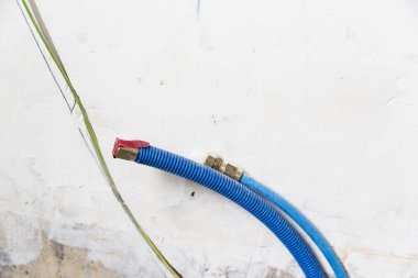 Duvardaki, Polipropilen Pex evde sıhhi tesisat su boruları yapılmıştır. Kanalizasyon boruları bir daire iç banyoda yükleme yenileme çalışmaları sırasında. Mavi plastik drenaj borusu için kullanılan su