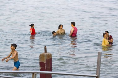 Kimliği belirsiz Hint hacı kadın erkek çocuk aile sahilde, denize arıtma arıtma için tapınağın gitmeden önce banyo grubu.