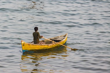 Yaklaşık, Rameswaram, Rameshwaram, Pamban Adası, Tamil Nadu, Hindistan - 2018 Mart. Kimliği belirsiz zavallı yerel geleneksel balıkçı çok küçük renkli ahşap tekne ile sahilde balık tutma.