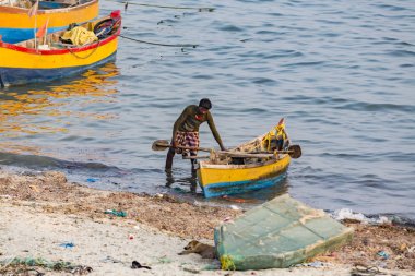 Yaklaşık, Rameswaram, Rameshwaram, Pamban Adası, Tamil Nadu, Hindistan - 2018 Mart. Kimliği belirsiz zavallı yerel geleneksel balıkçı çok küçük renkli ahşap tekne ile sahilde balık tutma.