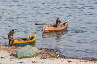 Yaklaşık, Rameswaram, Rameshwaram, Pamban Adası, Tamil Nadu, Hindistan - 2018 Mart. Kimliği belirsiz zavallı yerel geleneksel balıkçı çok küçük renkli ahşap tekne ile sahilde balık tutma.