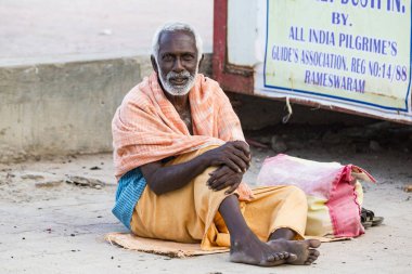 Yaklaşık, Rameswaram, Rameshwaram, Pamban Adası, Tamil Nadu, Hindistan - 2018 Mart. Kimliği belirsiz Sadhus hacılar adam portresi yolda yemek için bekleyen oturan Turuncu elbise giymiş. Bir Hindu hac inanç ve kitle sacre banyoda olduğunu