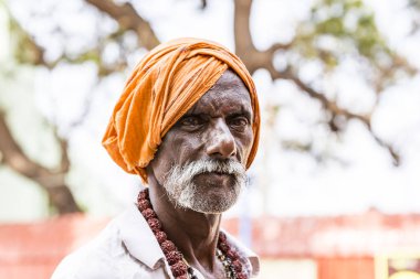 Yaklaşık, Rameswaram, Rameshwaram, Pamban Adası, Tamil Nadu, Hindistan - 2018 Mart. Kimliği belirsiz Sadhus hacılar adam portresi yolda yemek için bekleyen oturan Turuncu elbise giymiş. Bir Hindu hac inanç ve kitle sacre banyoda olduğunu