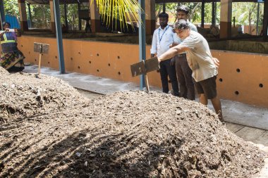 Yaklaşık, Puduchery, Pondichery, Tamil Nadu, Hindistan - 2018 Mart. Kompost depolama vasıl bakan kimliği belirsiz kişiler. Kompost toprak, organik bitki gübre plantation için meyve sebze oranic atık ile yaptı. Geri dönüşüm çevre