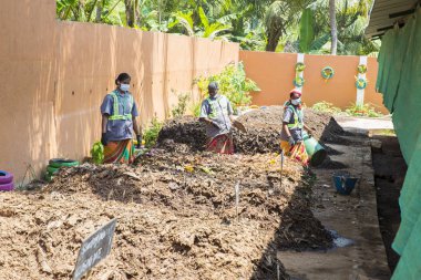 Yaklaşık, Puduchery, Pondichery, Tamil Nadu, Hindistan - 2018 Mart. Kompost depolama vasıl bakan kimliği belirsiz kişiler. Kompost toprak, organik bitki gübre plantation için meyve sebze oranic atık ile yaptı. Geri dönüşüm çevre