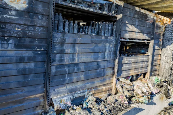 damaged industry supermarket metallic facade after arson fire with burnt debris after intense burning fire disaster ruins waiting for investigation for insurance