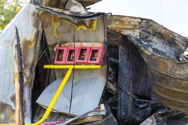 damaged industry supermarket metallic facade after arson fire with burnt debris after intense burning fire disaster ruins waiting for investigation for insurance, with gas emergency stop system protection