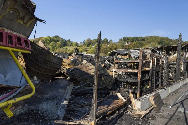 damaged industry supermarket metallic facade after arson fire with burnt debris after intense burning fire disaster ruins waiting for investigation for insurance