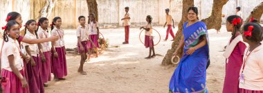 Puduchery, Hindistan - Mart Circa, 2018: tanımlanamayan öğretmen gülümseyen, mutlu, kız ve erkek çocuklar oyun oynarken, komik, outoor, bahçesi heyecanlı. Çok ırklı ve sadaka sivil toplum kavramı. Panoramik afiş