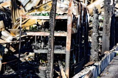 Şiddetli yangın felaketinin ardından yanan siyah molozlarla yanan kundaklama sonrası raflardaki hasarlı süpermarket cam plastik şişeleri sigorta araştırması için bekletiliyor. Doymuş karşıtlık etkisi dramatik atmosfer