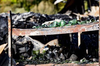 Şiddetli yangın felaketinin ardından yanan siyah molozlarla yanan kundaklama sonrası raflardaki hasarlı süpermarket cam plastik şişeleri sigorta araştırması için bekletiliyor. Doymuş karşıtlık etkisi dramatik atmosfer